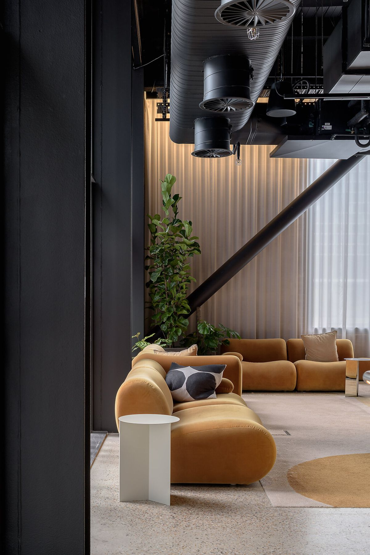 Loungehoek met okerkleurige banken en vide